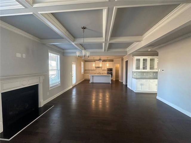 unfurnished living room featuring beamed ceiling, coffered ceiling, dark hardwood / wood-style flooring, and crown molding