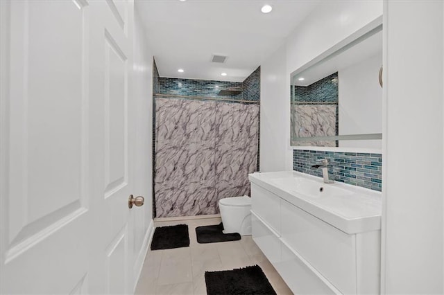 bathroom featuring vanity, decorative backsplash, a shower, and toilet