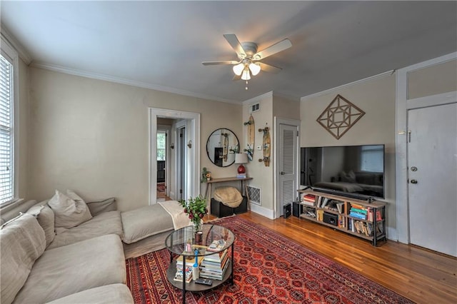 living room featuring ceiling fan, hardwood / wood-style flooring, and crown molding