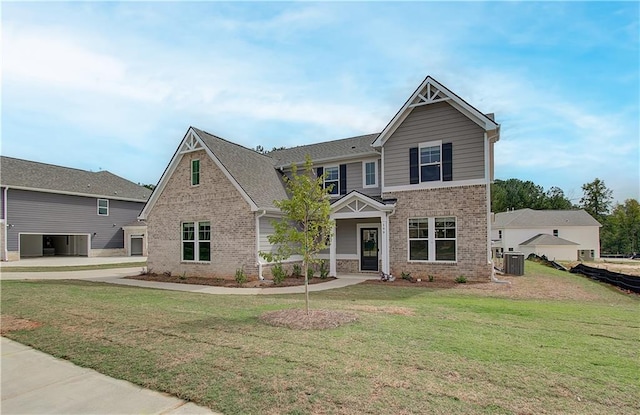 craftsman house with a front yard and central air condition unit