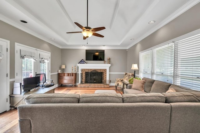 955 Chandler Haulk Rd, Loganville, GA 30052 - living area featuring a raised ceiling, light wood finished floors, a ceiling fan, ornamental molding, and a fireplace