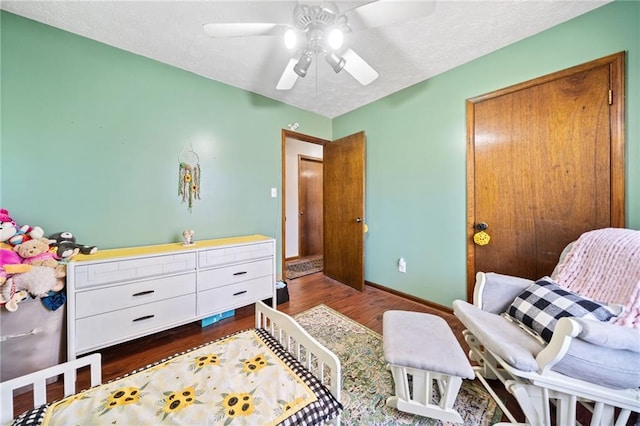 bedroom with ceiling fan, baseboards, a textured ceiling, and wood finished floors