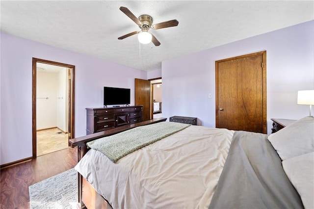 bedroom featuring ceiling fan, a textured ceiling, baseboards, and wood finished floors