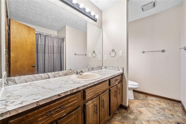 full bath with vanity, baseboards, visible vents, a textured ceiling, and toilet