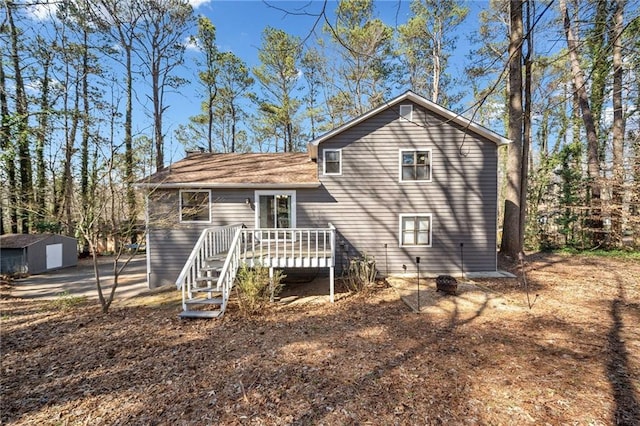 rear view of house featuring an outdoor structure, a deck, and stairs