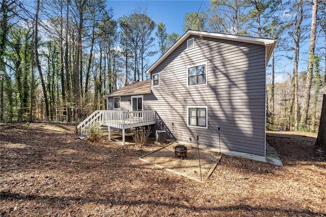 rear view of property featuring a deck, central AC, and an outdoor fire pit