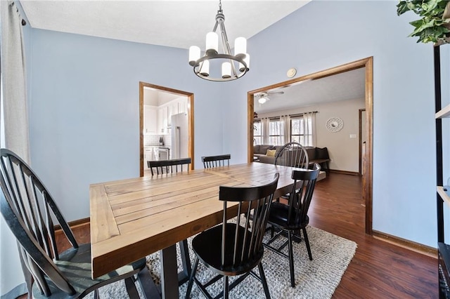 dining area with baseboards, lofted ceiling, an inviting chandelier, and wood finished floors