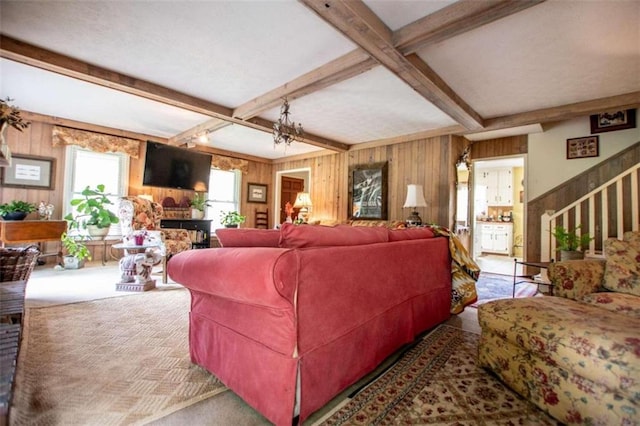 carpeted living room featuring wood walls and beamed ceiling