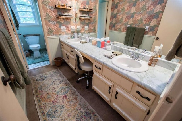 bathroom featuring toilet and dual bowl vanity