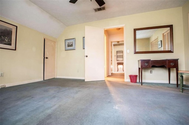 interior space with ceiling fan, vaulted ceiling, and dark carpet