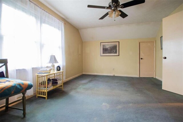 carpeted bedroom with ceiling fan and vaulted ceiling