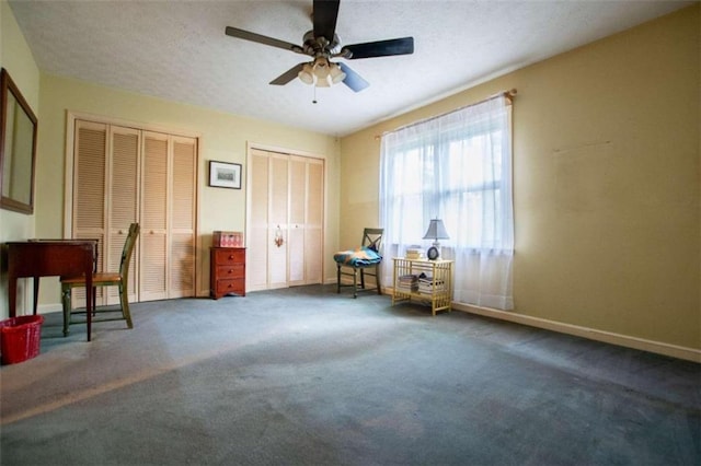 sitting room with ceiling fan and carpet