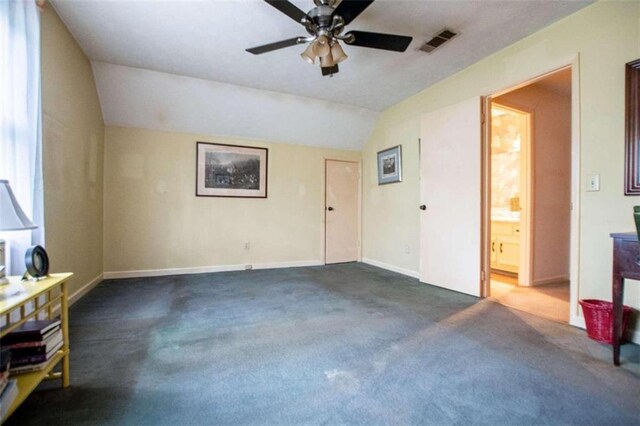 unfurnished room featuring ceiling fan, dark carpet, and lofted ceiling