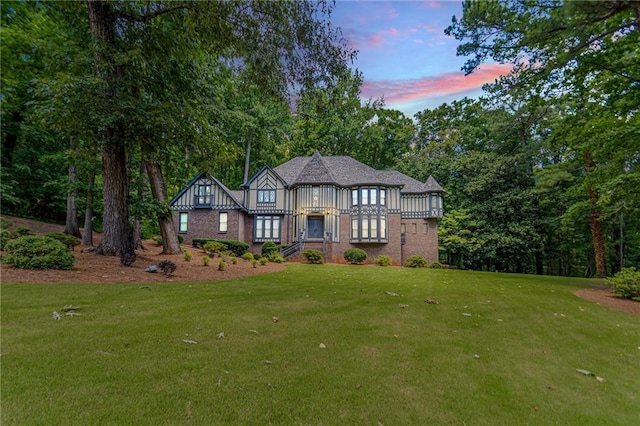 english style home with a lawn