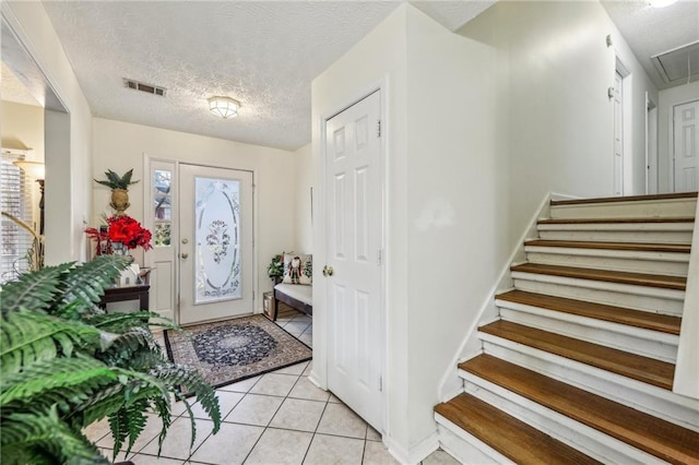 tiled entrance foyer featuring a textured ceiling