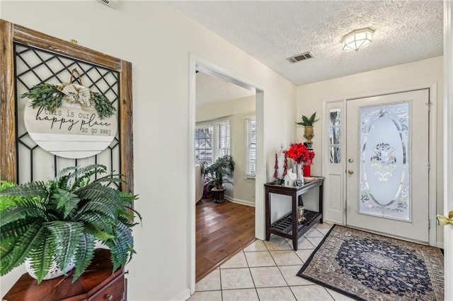 entryway featuring light hardwood / wood-style floors and a textured ceiling