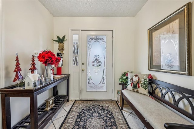 tiled entryway featuring a textured ceiling