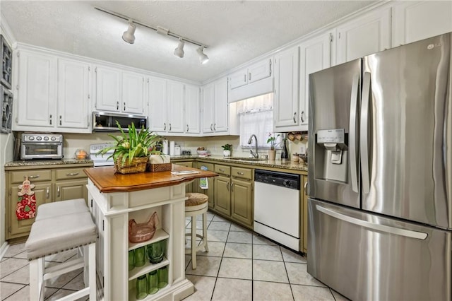 kitchen featuring a kitchen breakfast bar, stainless steel appliances, white cabinetry, and sink