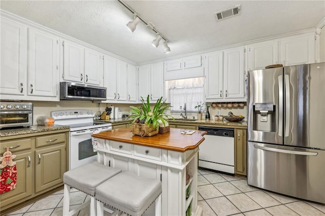 kitchen with white cabinetry, sink, stainless steel appliances, a textured ceiling, and light tile patterned floors