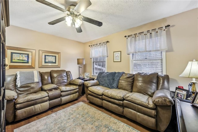 living room with hardwood / wood-style floors, a textured ceiling, and ceiling fan