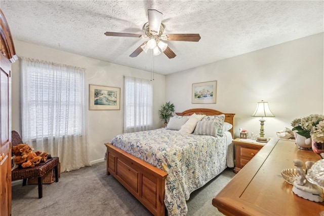 carpeted bedroom with ceiling fan and a textured ceiling