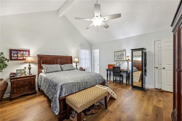 bedroom featuring hardwood / wood-style floors, ceiling fan, and lofted ceiling with beams