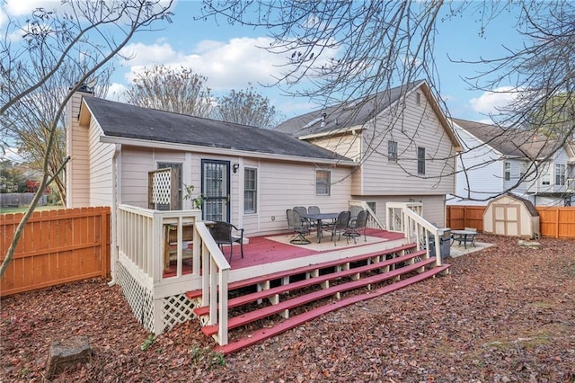 rear view of property featuring a storage unit and a deck