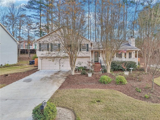 split level home featuring a front yard, a porch, and a garage