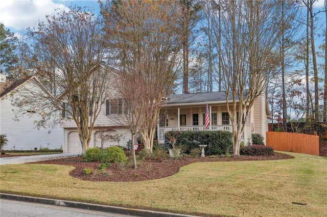 view of front of property featuring a front lawn, covered porch, and a garage