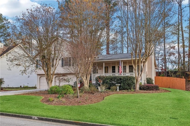 view of front of home featuring covered porch, a front yard, and a garage