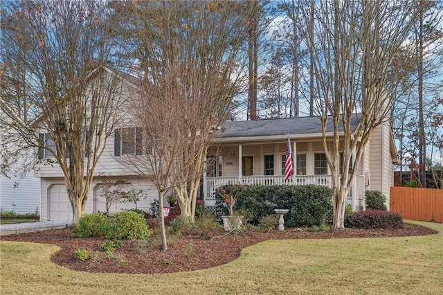 view of front of home with covered porch, a garage, and a front lawn