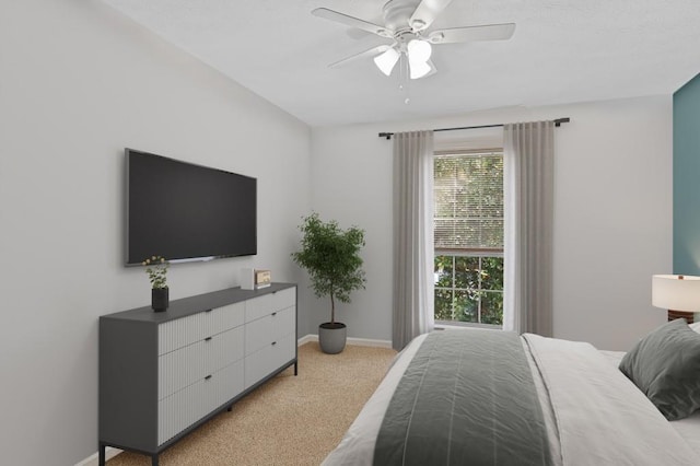 bedroom with a ceiling fan, light colored carpet, and baseboards