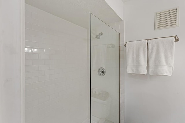 full bath featuring visible vents and a tile shower