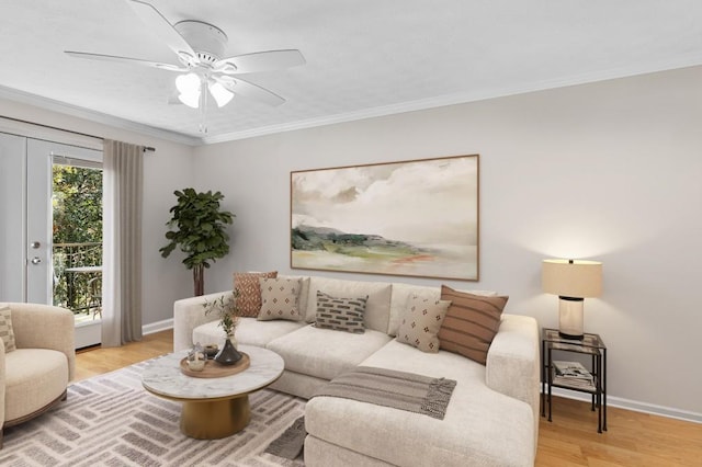 living area with baseboards, wood finished floors, ceiling fan, and ornamental molding