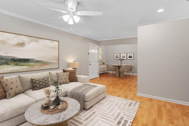 living area with recessed lighting, light wood-style flooring, ornamental molding, ceiling fan, and baseboards