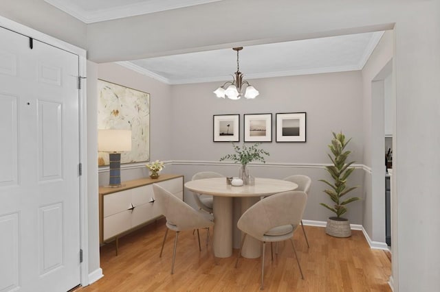 dining area with crown molding, light wood finished floors, a chandelier, and baseboards