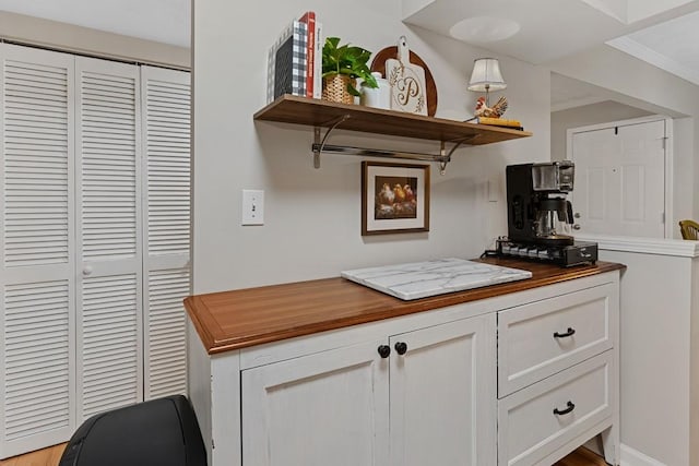 kitchen featuring ornamental molding, wooden counters, open shelves, and white cabinetry
