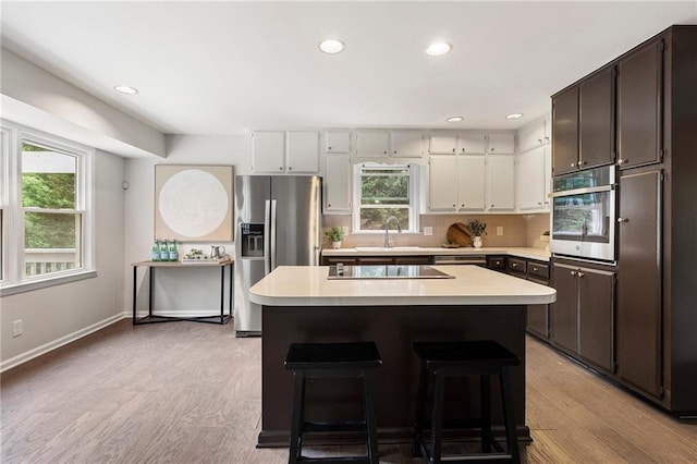 3131 Garden Lane Dr, Marietta, GA 30062 - kitchen featuring appliances with stainless steel finishes, light countertops, a kitchen island, a sink, and recessed lighting