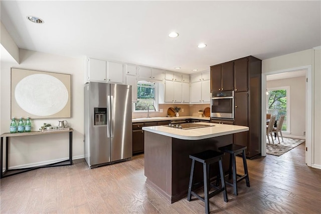 3131 Garden Lane Dr, Marietta, GA 30062 - kitchen featuring stainless steel appliances, light countertops, healthy amount of natural light, wood finished floors, and recessed lighting