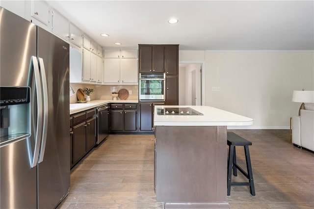 3131 Garden Lane Dr, Marietta, GA 30062 - kitchen with appliances with stainless steel finishes, a center island, light countertops, light wood-type flooring, and recessed lighting