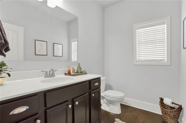 bathroom with wood-type flooring, vanity, and toilet