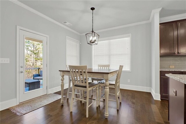 dining space with a chandelier, dark wood-type flooring, and ornamental molding