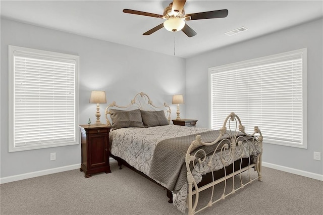 bedroom featuring multiple windows, ceiling fan, and light colored carpet