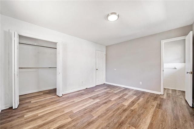 unfurnished bedroom featuring baseboards and wood finished floors