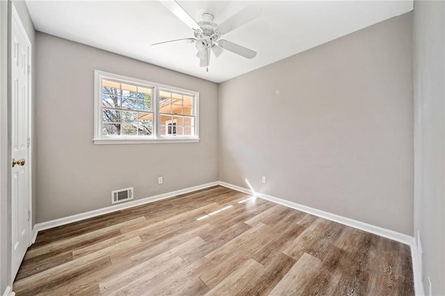 empty room featuring visible vents, baseboards, and wood finished floors