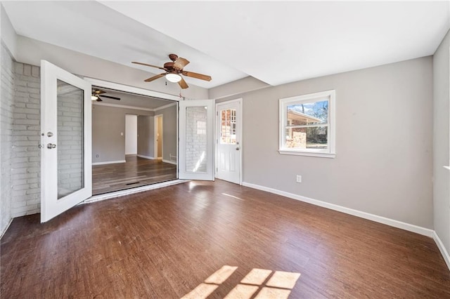 unfurnished living room with a ceiling fan, baseboards, and wood finished floors