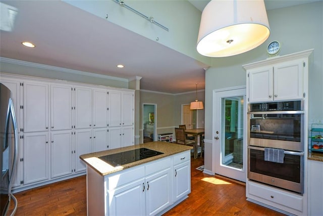 kitchen with appliances with stainless steel finishes, dark wood-style floors, white cabinetry, ornamental molding, and recessed lighting