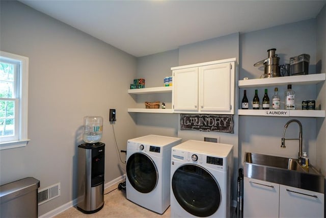 washroom with washer and dryer, cabinet space, and baseboards