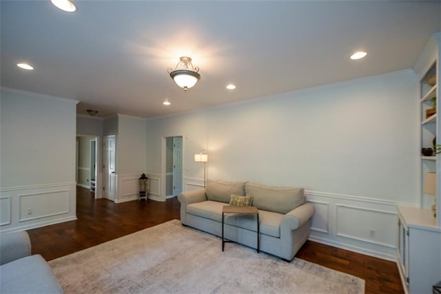 living room with a decorative wall, recessed lighting, wainscoting, wood finished floors, and ornamental molding