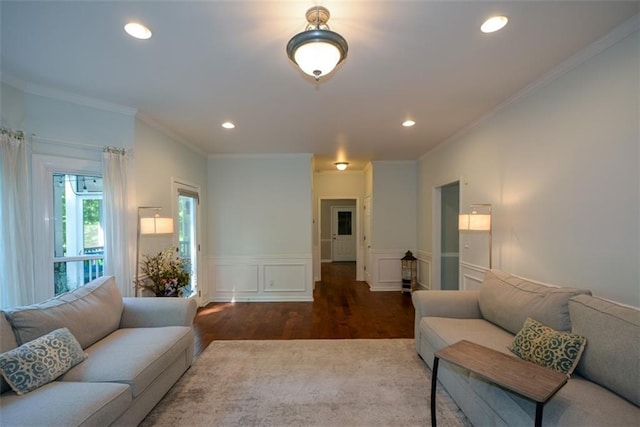 living area with wood finished floors, crown molding, a wainscoted wall, recessed lighting, and a decorative wall
